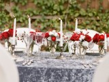 a grey marbleized table runner and bold red and white floral centerpieces plus tall candles