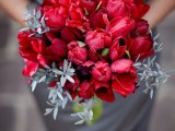a short draped grey dress and a red bouquet are a gerat contrasting combo for such a wedding