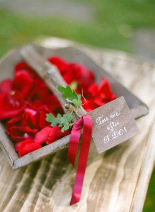 a wooden basket with red blooms, a red ribbona nd greenery on it is great for a little flower girl at your wedding