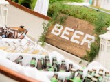 a simple and relaxed wedding bar idea – a boat with greenery, candle lanterns and a sign and lots and lots of beer in boxes with ice is a great idea