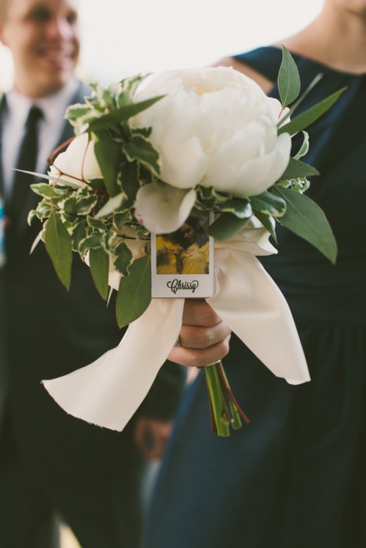 A bridesmaid bouquet with a Polaroid attached to find out where and whose bouquet is