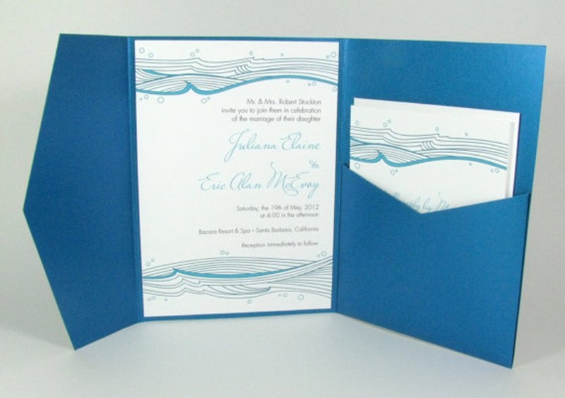 A blue, aqua and white beach wedding invitation suite in an envelope, with whale inspired prints that are all pretty and bold