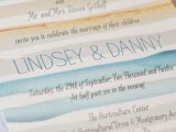 a bright watercolor wedding invitation with blue, mint and orange stripes, with blue letters and black calligraphy is a chic idea