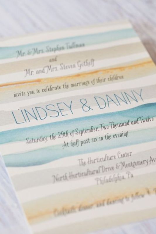 A bright watercolor wedding invitation with blue, mint and orange stripes, with blue letters and black calligraphy is a chic idea