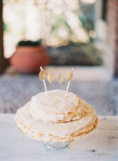 a crepe wedding cake topped with white buttercream, with a tiny gold leaf bunting on top is a cute idea for a tiny wedding