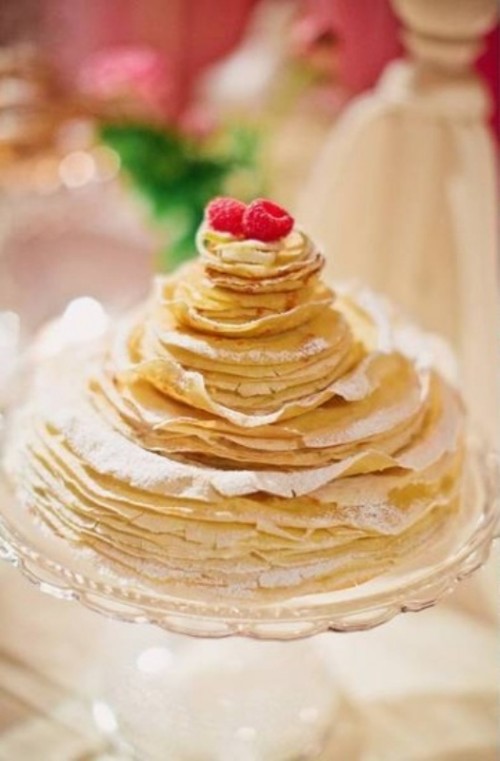 a crepe wedding cake with cream in between tiers, and some fresh berries on top is a gorgeous idea for a modern and laid-back wedding
