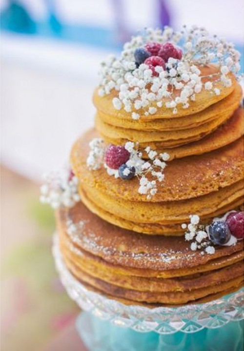 a pancake wedding cake topped with baby's breath, berries and sugar powder is a gorgeous idea for a relaxed summer wedding