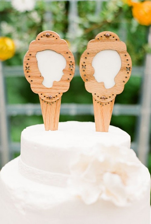 a white wedding cake topped with wooden silhouettes is a cool and lovely idea for a rustic wedding, you can make them yourself