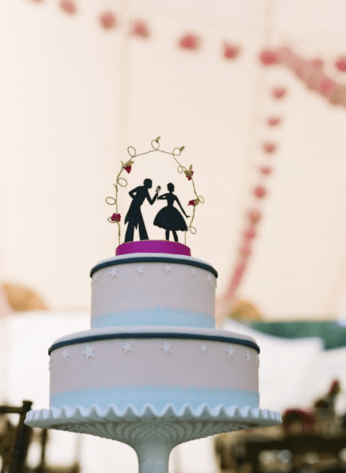 a pink and blue wedding cake with black ribbon and a black silhouette cake topper is a lovely and cool idea for a wedding with a vintage feel