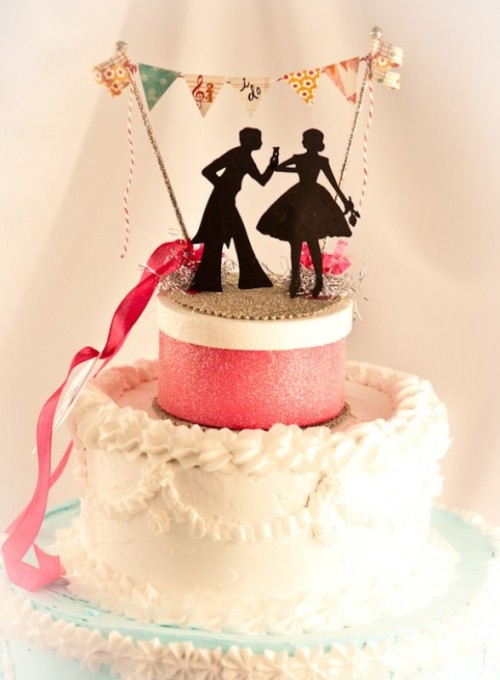a colorful wedding cake with a box and a black silhouette cake topper plus a colorful bunting is a gorgeous idea for a wedding