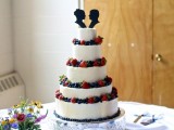 a white wedding cake topped with fresh berries and black head silhouette toppers is a lovely and cool idea