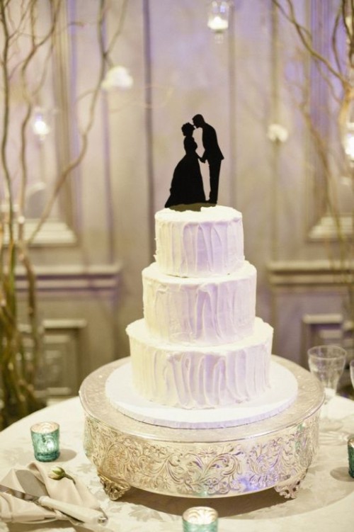a textural white wedding cake topped with a black couple silhouette is a classic idea for a vintage wedding