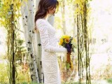 a rustic backyard wedding arch with greenery, sunflowers and yellow blooms and foliage on the ground is cute and cozy