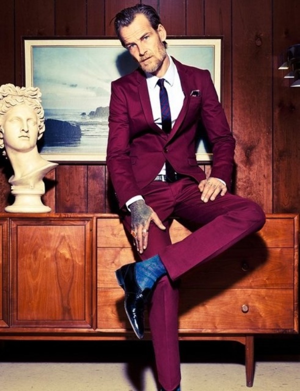 A fuchsia suit, a white shirt and a purple tie, black shoes are a bold combo for a daring groom