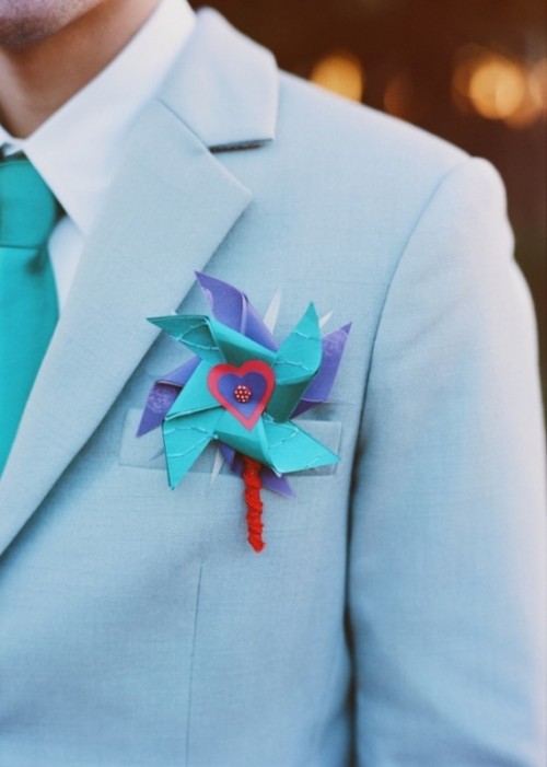 a light blue suit, a white shirt, a turquoise tie and a bright paper boutonniere for a fun touch