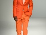 a bright orange suit, a white shirt, a bright orange tie and white sneakers for a bold and chic modern groom’s look