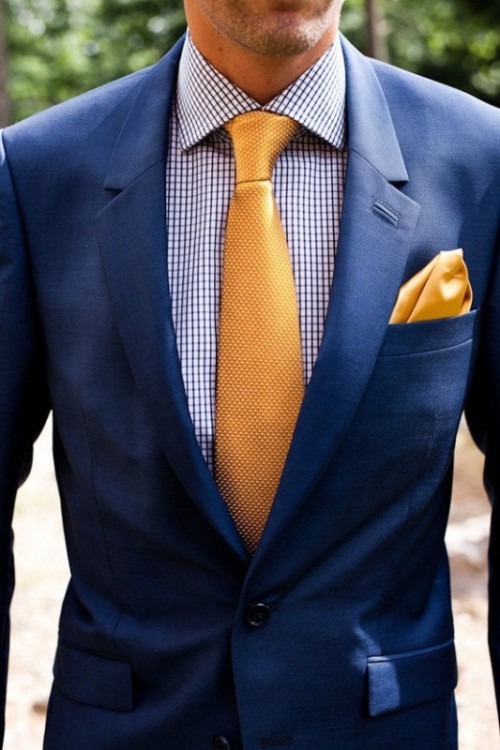 a navy suit, a printed blue shirt and a bright yellow tie and handkerchief for a bold and fun look