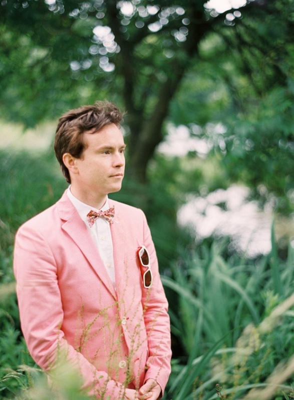 A pastel pink suit, a white shirt and a pink printed bow tie for a light and fun summer groom's look