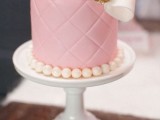 a pink patterned individual wedding cake with edible pearls and a large bow is an adorable piece for a glam wedding