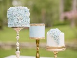 an assorment of blue mini cakes on gold stands, with ruffles and gold detailing for a romantic and refined wedding