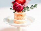 a naked individual wedding cake topped with burgundy and pink blooms and eucalyptus