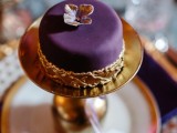 a deep purple individual wedding cake with an edible flower on top and some gold detailing is very refined