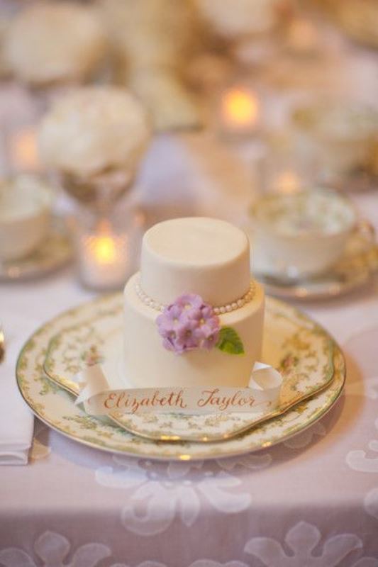 A neutral individual wedding cake with edible beads, flowers and leaves and a tag is an amazing and delicious idea