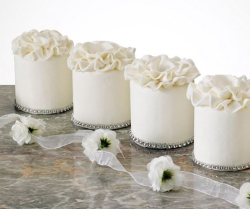 white individual wedding cakes with white sugar ruffles on top are delicious and look very chic