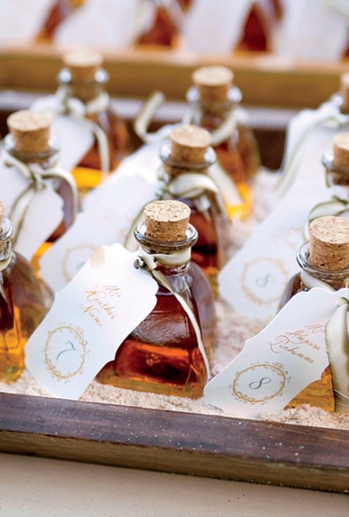 mini whiskey bottles with tags are cool wedding escort cards and cool drinkable wedding favors at the same time