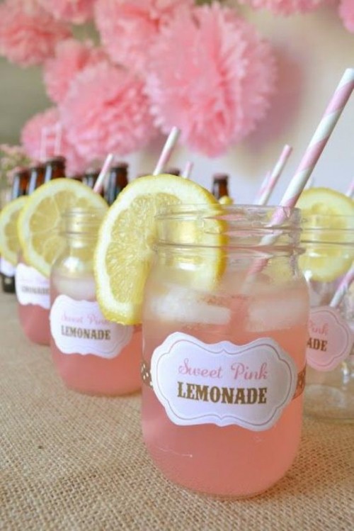 sweet pink lemonade with citrus slices and straws is an amazing idea for refreshing guests at a hot weather wedding