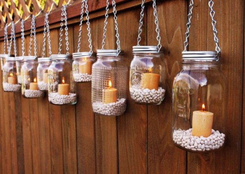 mason jars hanging on chain, with corn and pillar candles can decorate a rustic or some other wedding, for example, an industrial one
