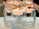 mason jars with floating candles and vine to wrap them are great to style your wedding in a rustic way
