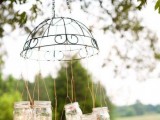 a creative outdoor wedding chandelier of a metal lampshade, hanging mason jars with candles is a lovely idea for a rustic or relaxed garden wedding