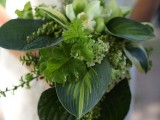 a greenery wedding bouquet with lush leaves, greenery, some white blooms looks very chic and very bold