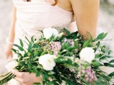 a greenery wedding bouquet with a catchy shape dotted with white and pink flowers is ideal for spring