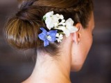 a tight and sleek low bun with a bit of fresh blooms on one side is a lovely idea for a destination wedding and not only