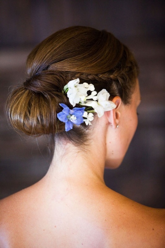 A tight and sleek low bun with a bit of fresh blooms on one side is a lovely idea for a destination wedding and not only
