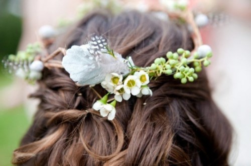 a simple twisted half updo with some white blooms and greenery is a pretty idea for a boho bride