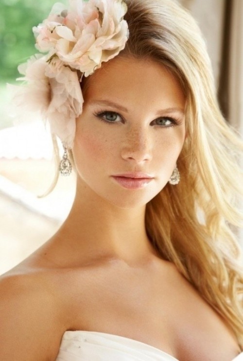 wavy and textural hair down with fresh blush blooms on one side to accent the hairstyle is a lovely idea for a destination wedding