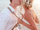 a messy and wavy low updo with locks down and with some fresh tropical blooms is a lovely idea for a beach wedding