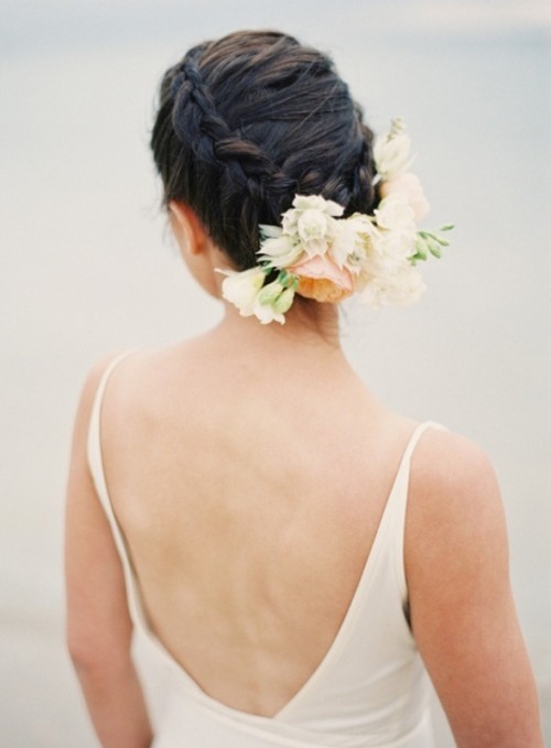 a braided low updo with neutral blooms attached is a beautiful idea for a neutral and delicate bridal look
