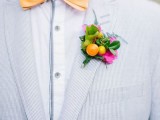 an orange bow tie paired with a colorful boutonniere, with greenery, kumquats and a hot pink touch for giving a bold spring or summer feel to the look