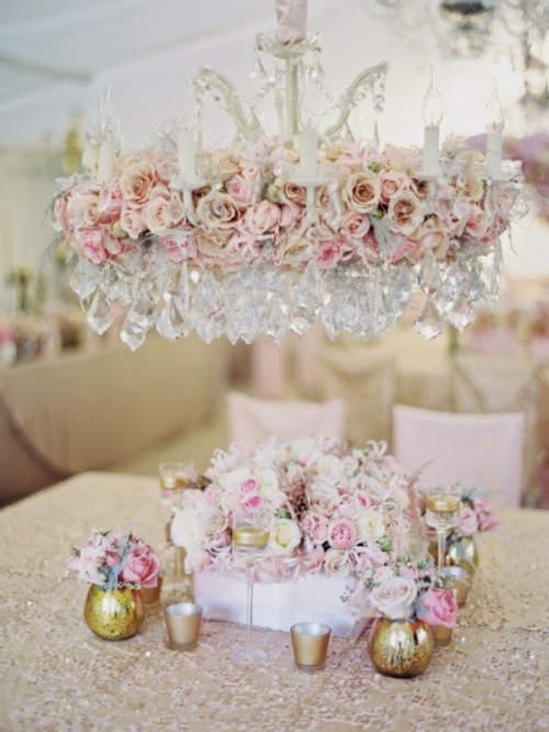 an oversized crystal chandelier covered with pink and blush blooms for a more exquisite and chic look