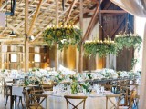 pretty chandeliers covered with greenery not only light up the space but also refresh it a lot giving it an outdoor feel