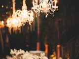 a neutral sophisticated wedding tablescape made more beautiful and chic with crystal chandeliers hanging over the table
