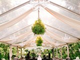 a gorgeous wedding tent with lots of greenery