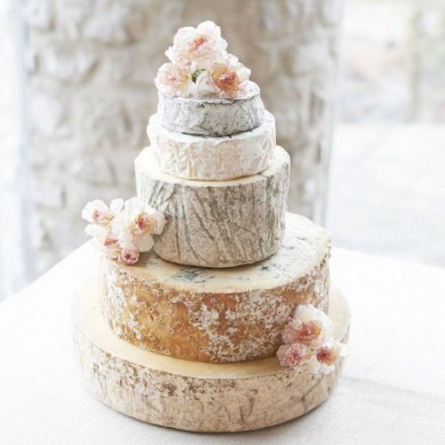 a delicate cheese wheel wedding cake topped with fresh blush blooms is a lovely idea for a spring or summer wedding