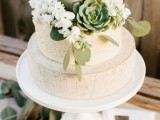 a cheese wheel wedding cake with white blooms, greenery and a succulent is a lovely idea for a spring or summer wedding