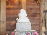 a romantic cheese wheel wedding cake topped with a heart-shaped cheese piece and decorated with pink roses for a rustic wedding