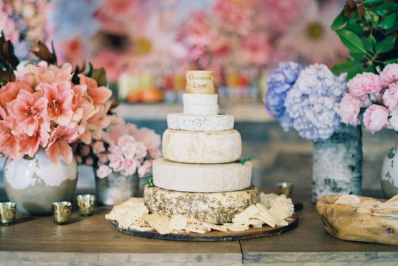 A small yet stylish cheese wheel wedding cake surrounded with pastel blooms is a beautiful idea for a spring or summer wedding